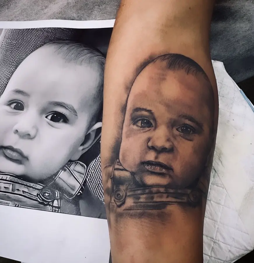 Realistic baby portrait tattoo showcasing detailed skin tones and expression by Rahma
