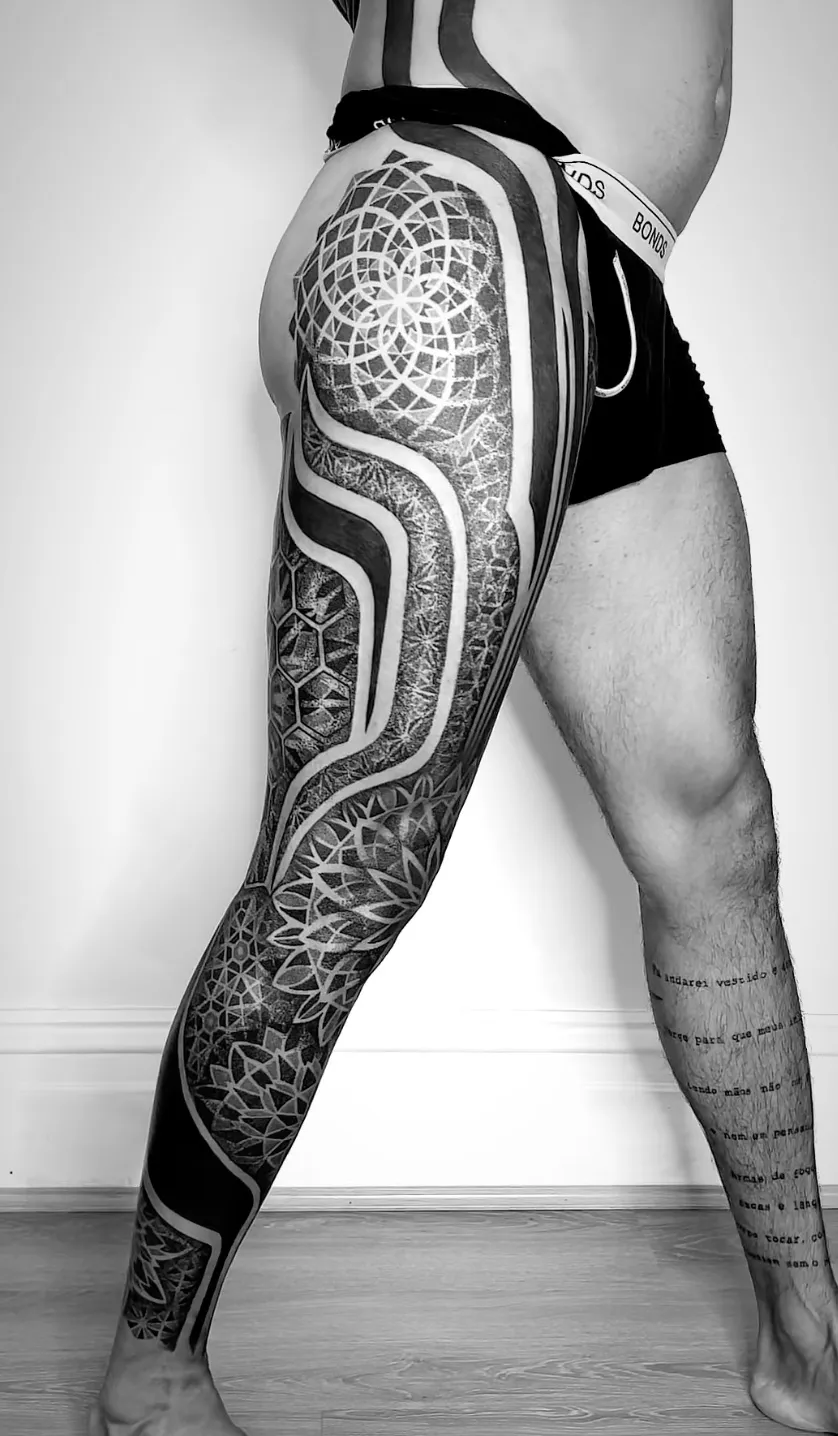 Bold blackwork leg sleeve with geometric patterns and negative space by Alex Berin