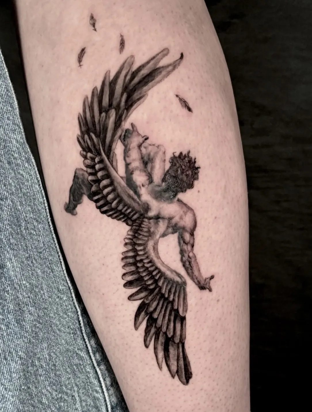 Mythological winged figure tattoo with detailed anatomy and feathers