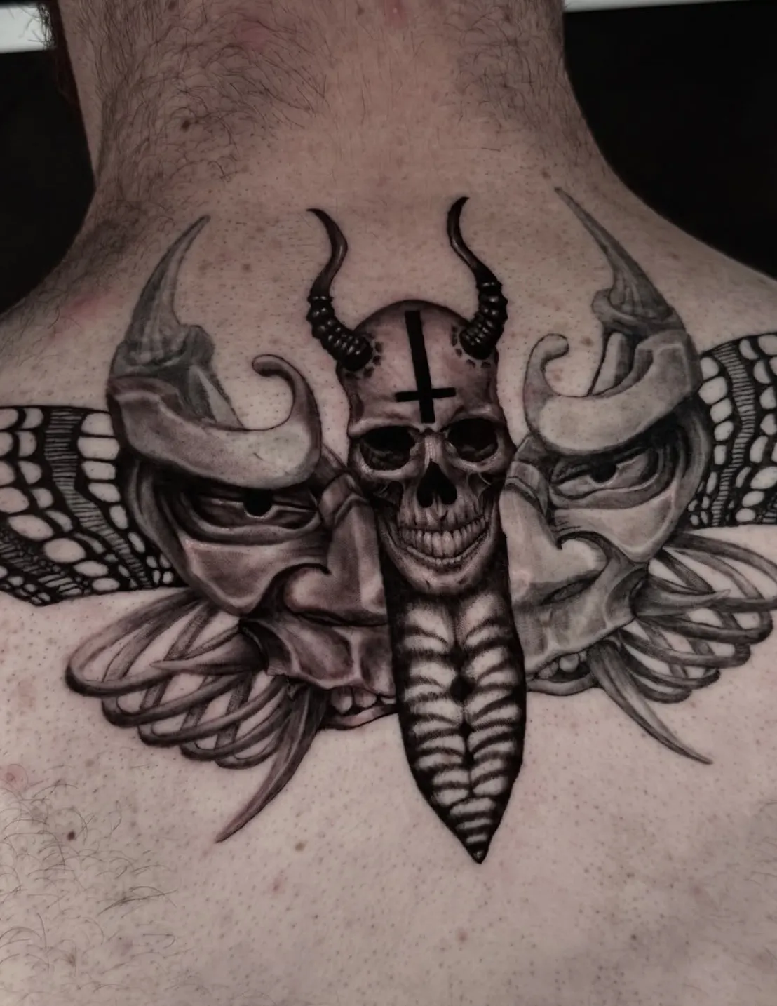 Detailed skull tattoo with horned elements and intricate design work