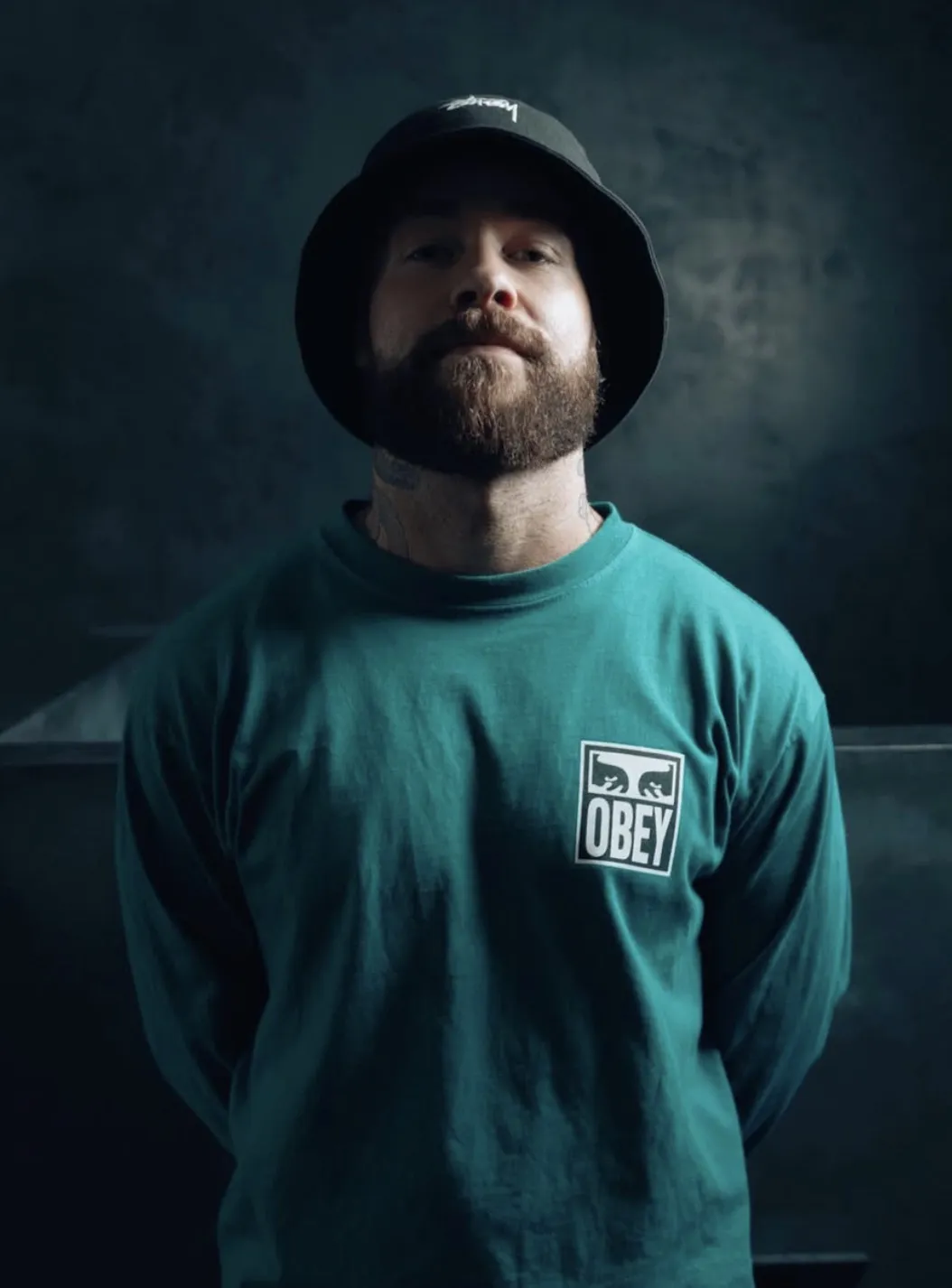 Tattoo artist Luke Bullmore from Omnia Tattoo Studio in a bucket hat and teal sweatshirt