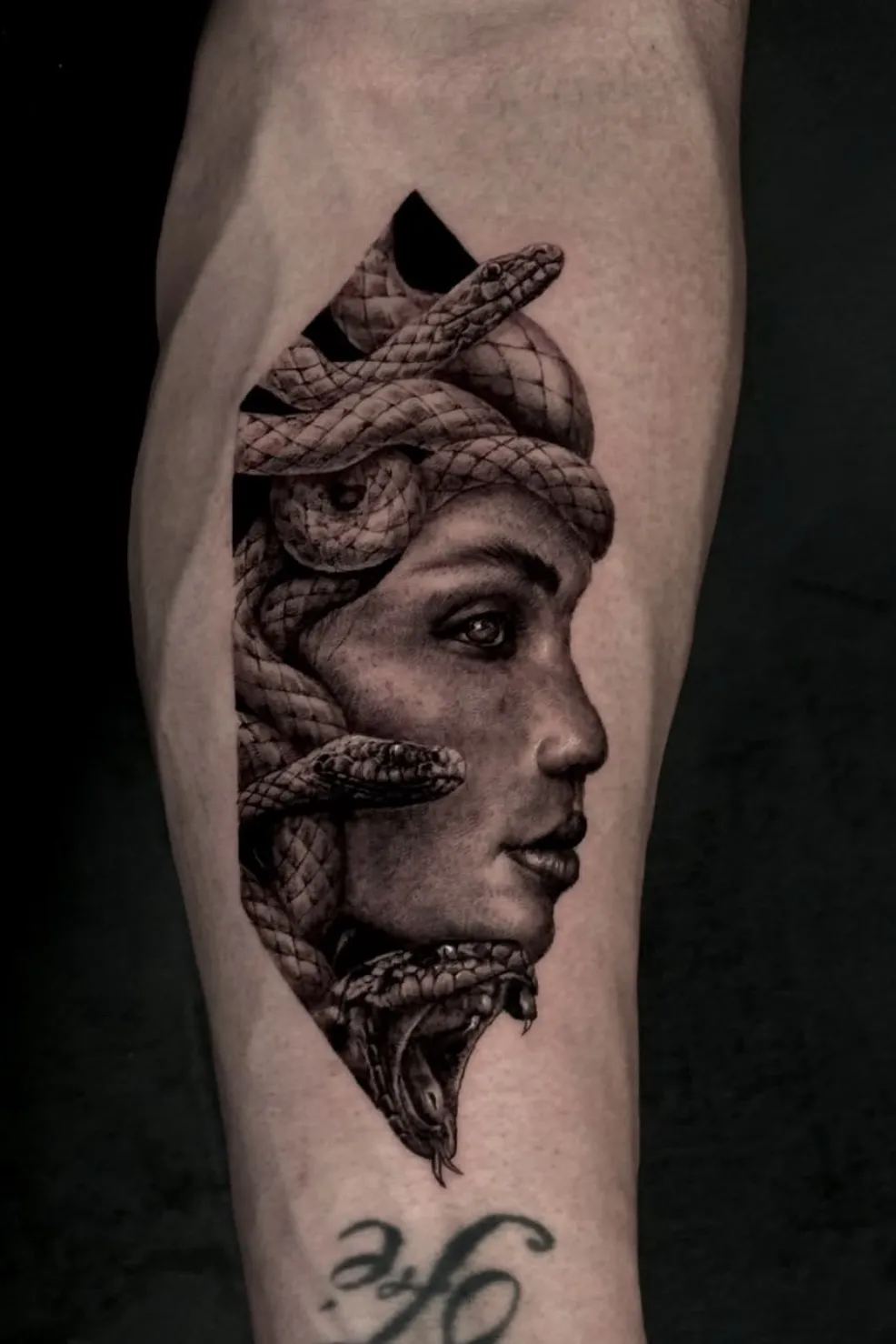 Portrait tattoo of woman with snake imagery incorporated into the design